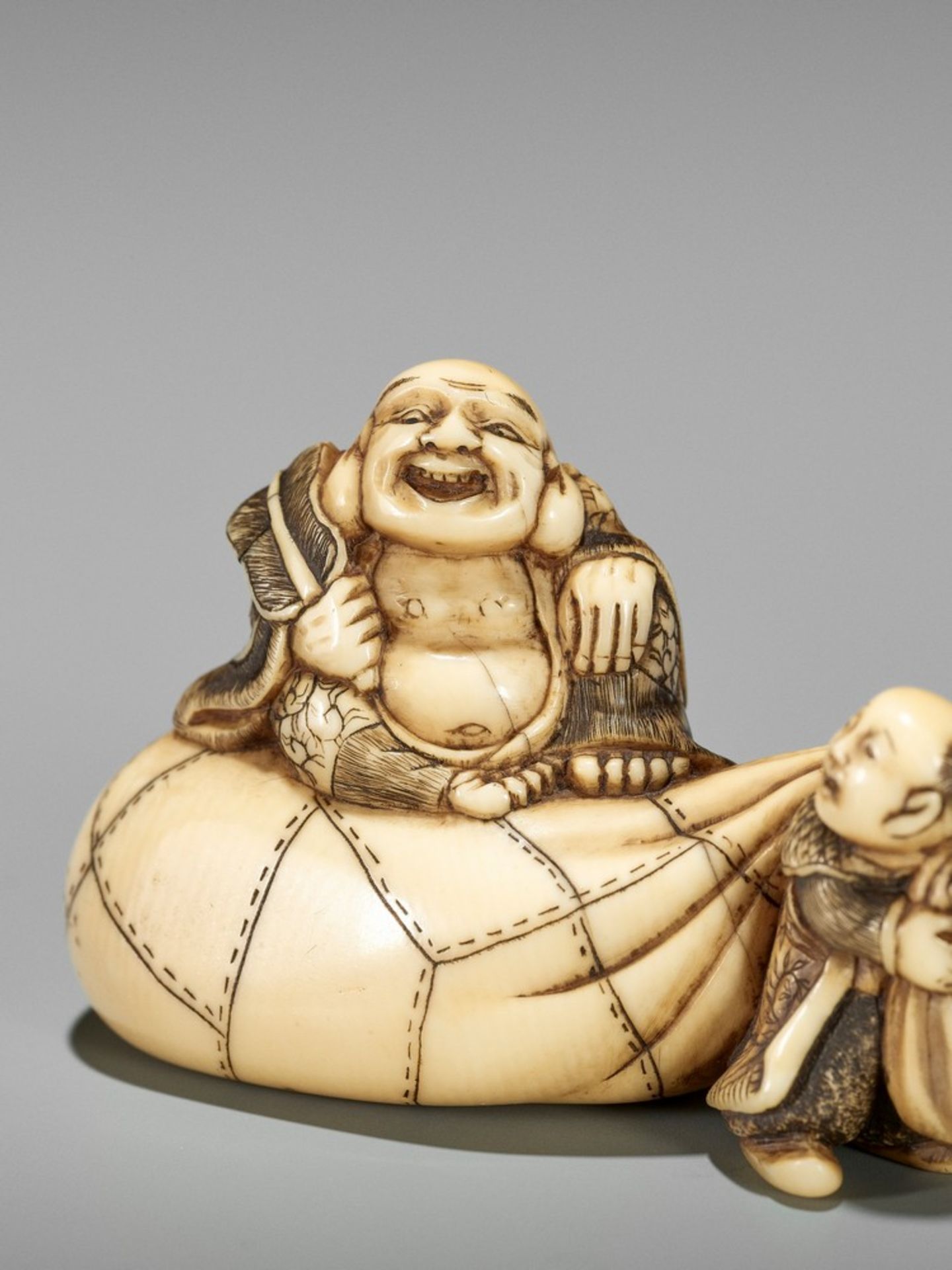 AN IVORY NETSUKE OF HOTEI ON HIS TREASURE BAG BEING PULLED BY A KARAKO UnsignedJapan, Kyoto, first - Bild 8 aus 10