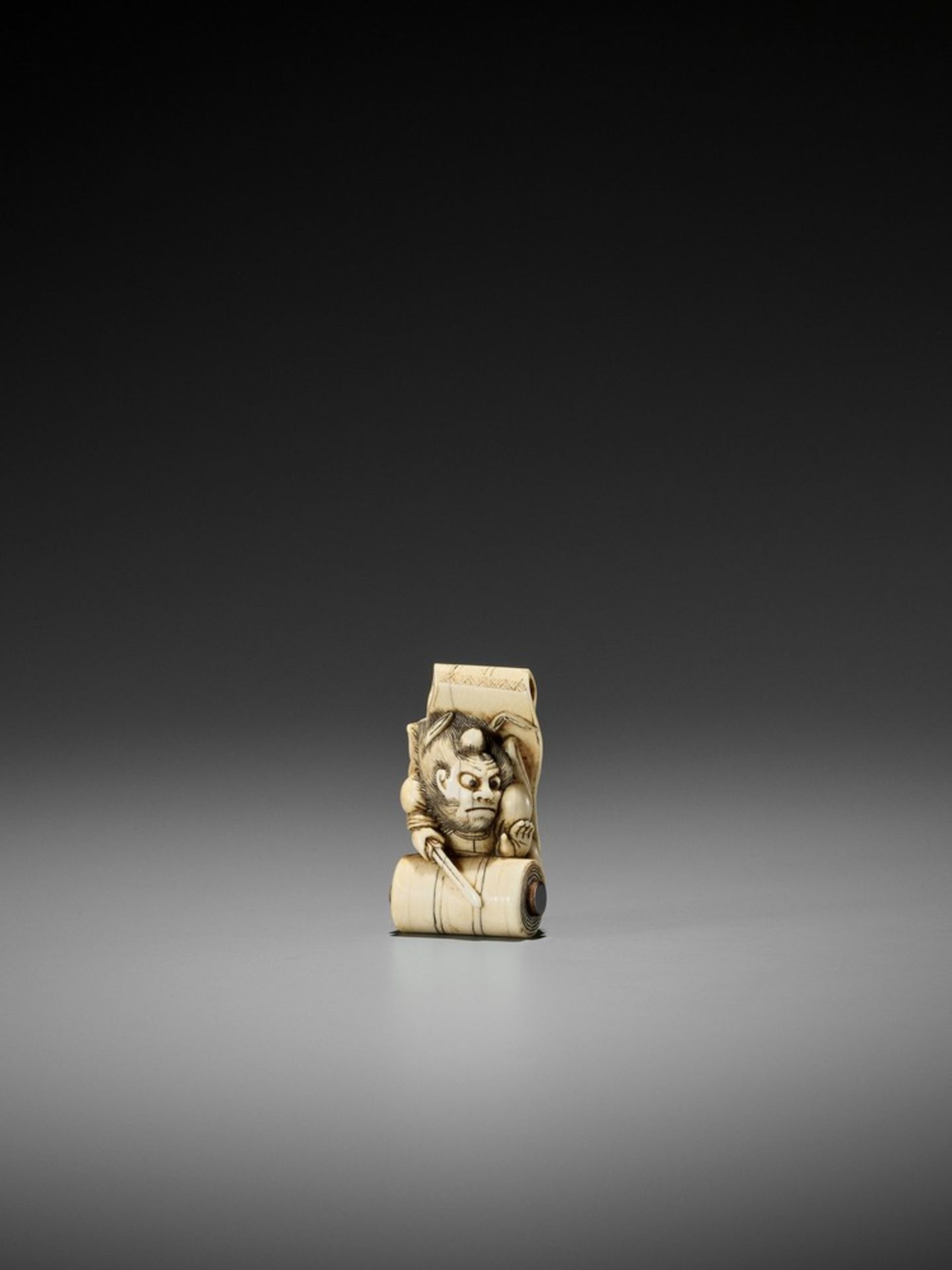 A FINE IVORY NETSUKE OF SHOKI EMERGING FROM A SCROLL ATTRIBUTED TO HIDEMASA Attributed to