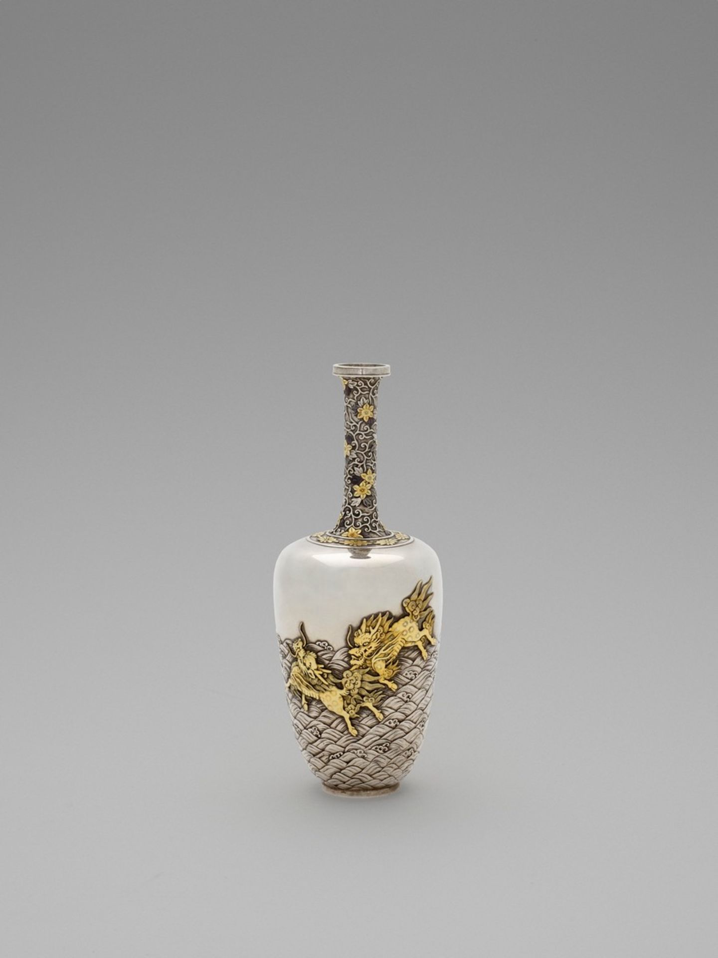 A SPECTACULAR GOLD-INLAID ‘KIRIN AND WAVES’ SILVER VASE Japan, Meiji period (1868-1912)The silver