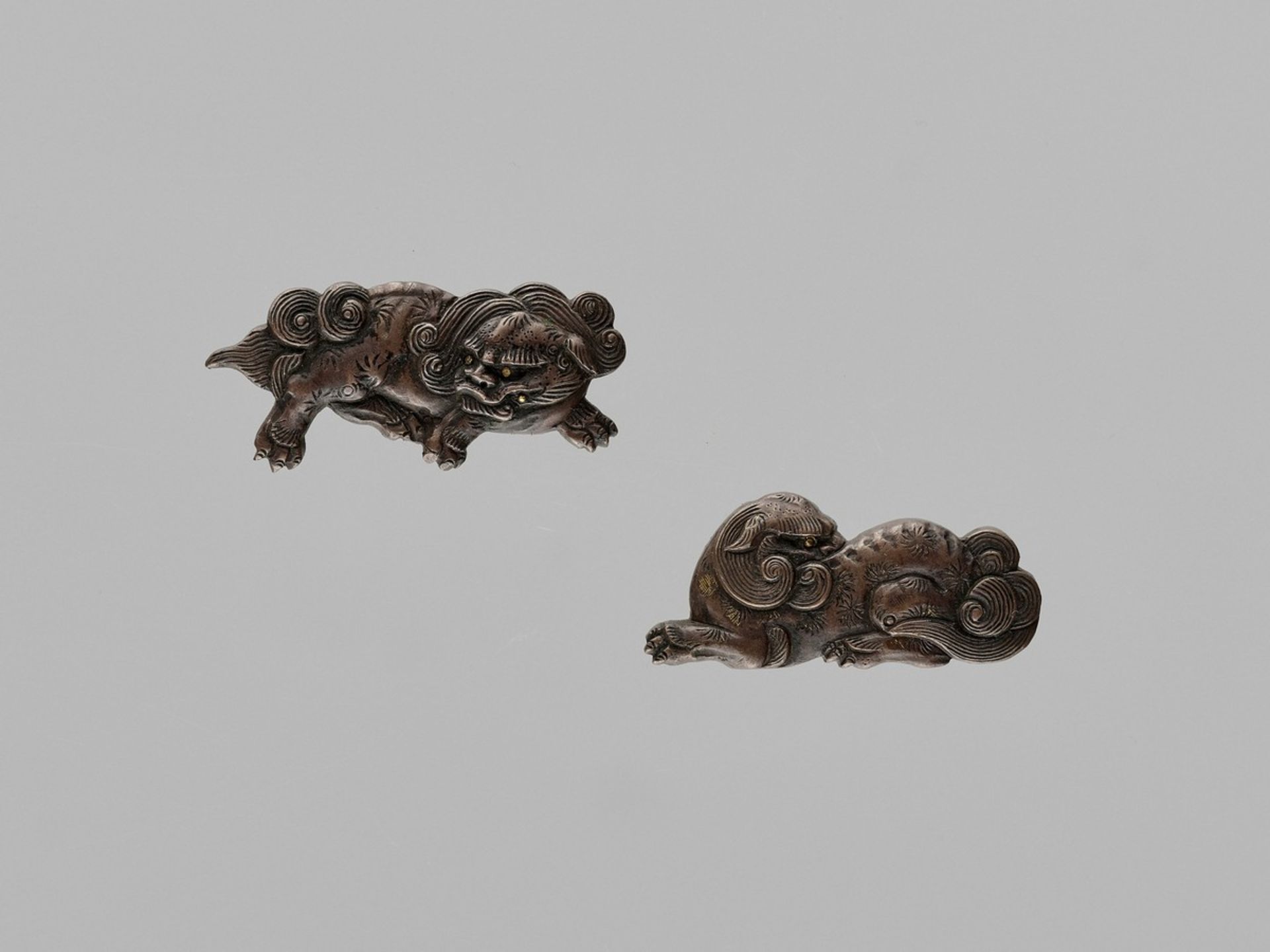 A FINE PAIR OF COPPER MENUKI DEPICTING SHISHI Japan, 19th century, Edo period (1615-1868)Each carved