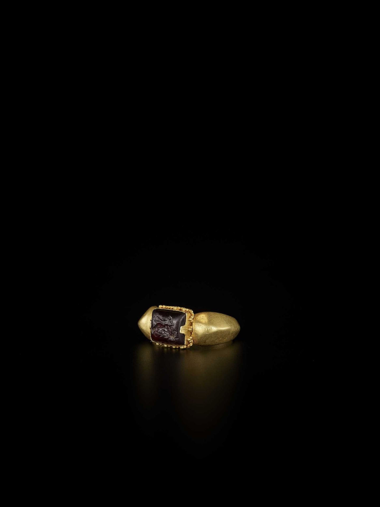 A PYU GOLD RING WITH RUBY INTAGLIO OF A MYTHICAL BEAST