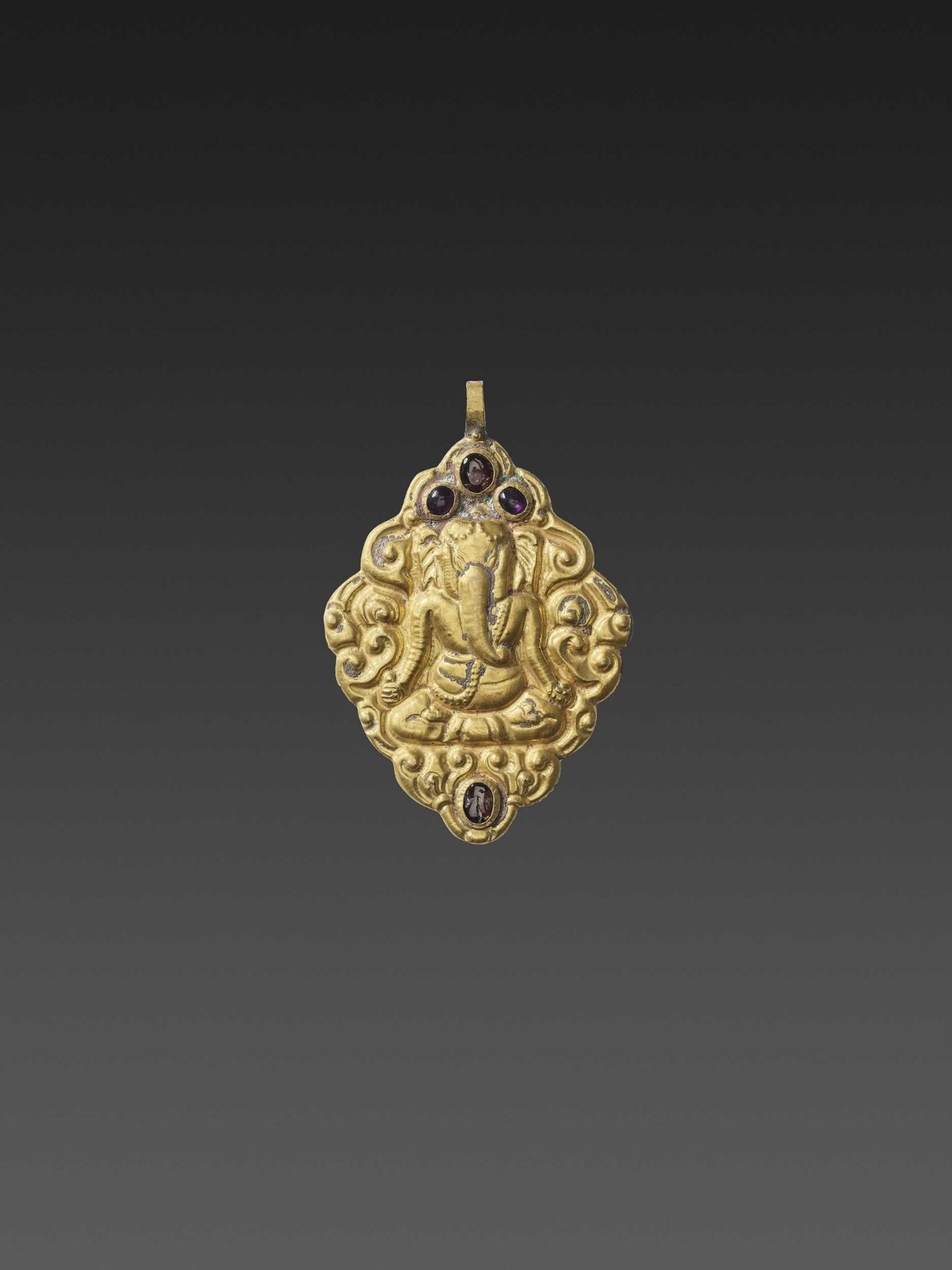 A CHAM GEMSTONE-SET GOLD REPOUSSÉ PENDANT DEPICTING GANESHA