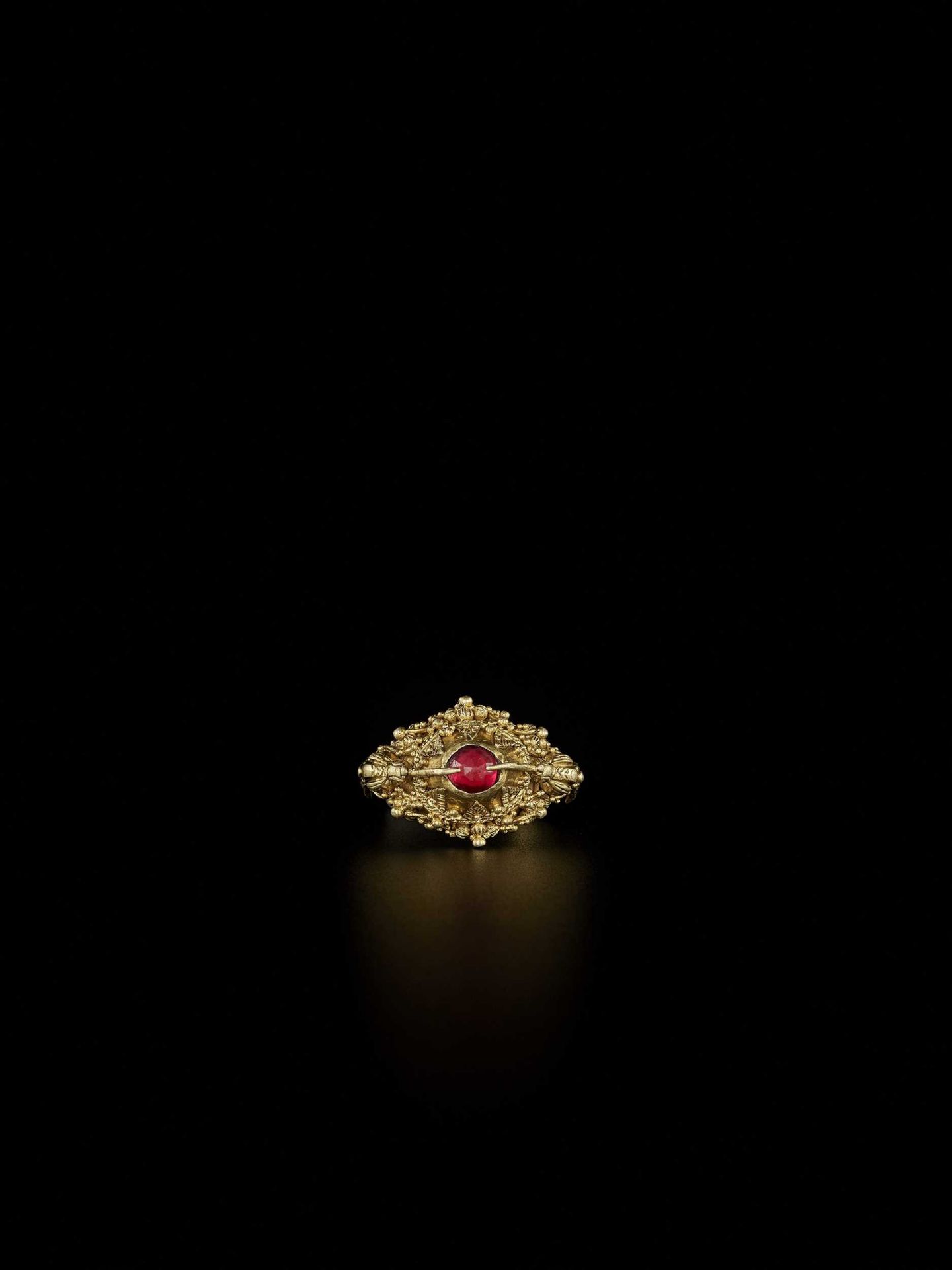 A FINE INDONESIAN RUBY-SET GOLD REPOUSSÉ RING