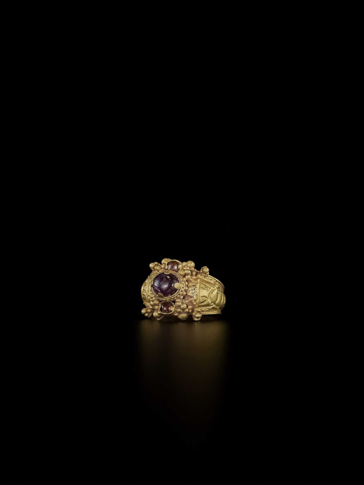 A CHAM AMETHYST AND CRYSTAL-SET GOLD REPOUSSÉ RING WITH ELEPHANT HEADS