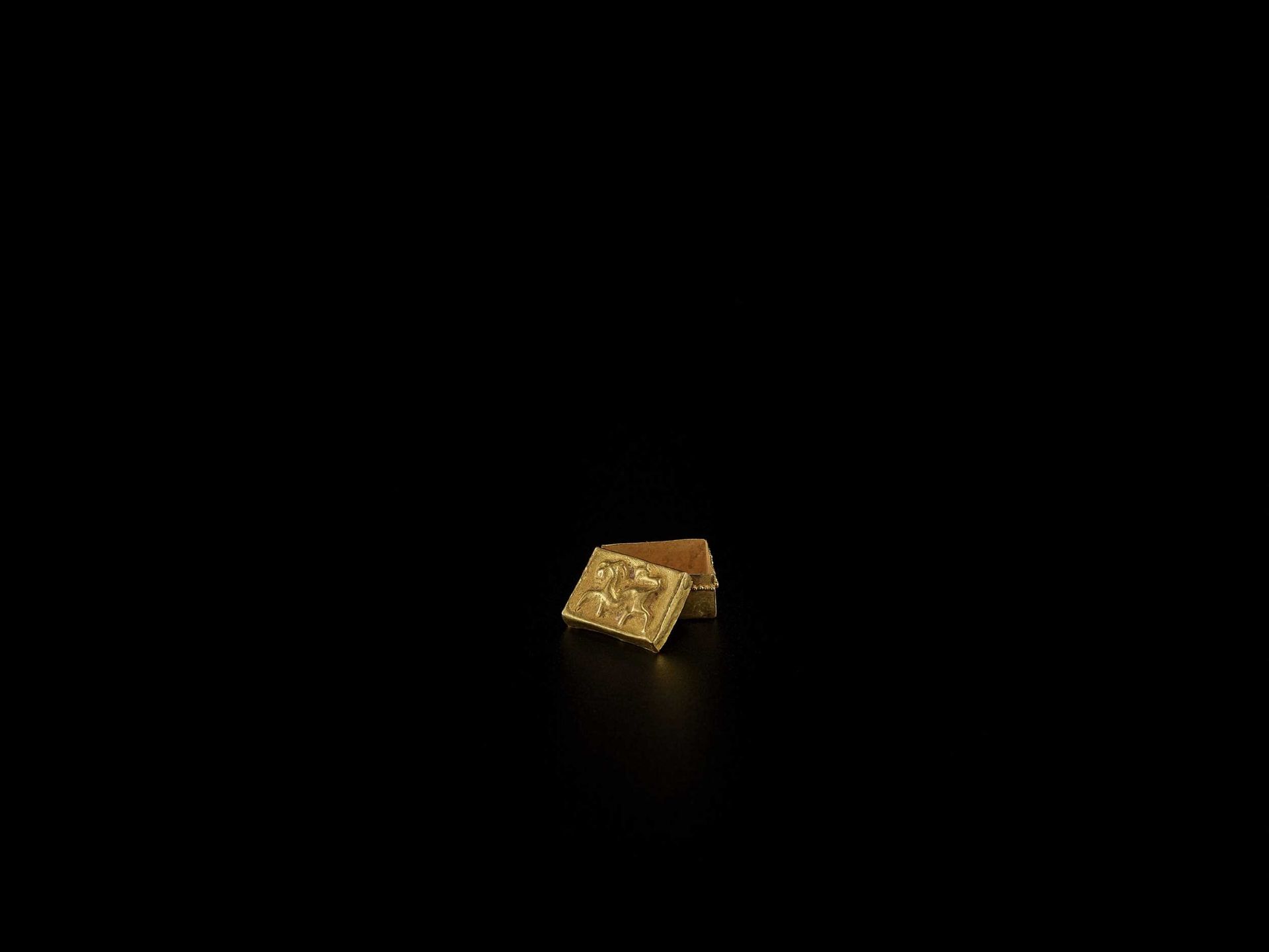 A BACTRIAN GOLD REPOUSSÉ MINIATURE BOX AND COVER WITH A LION