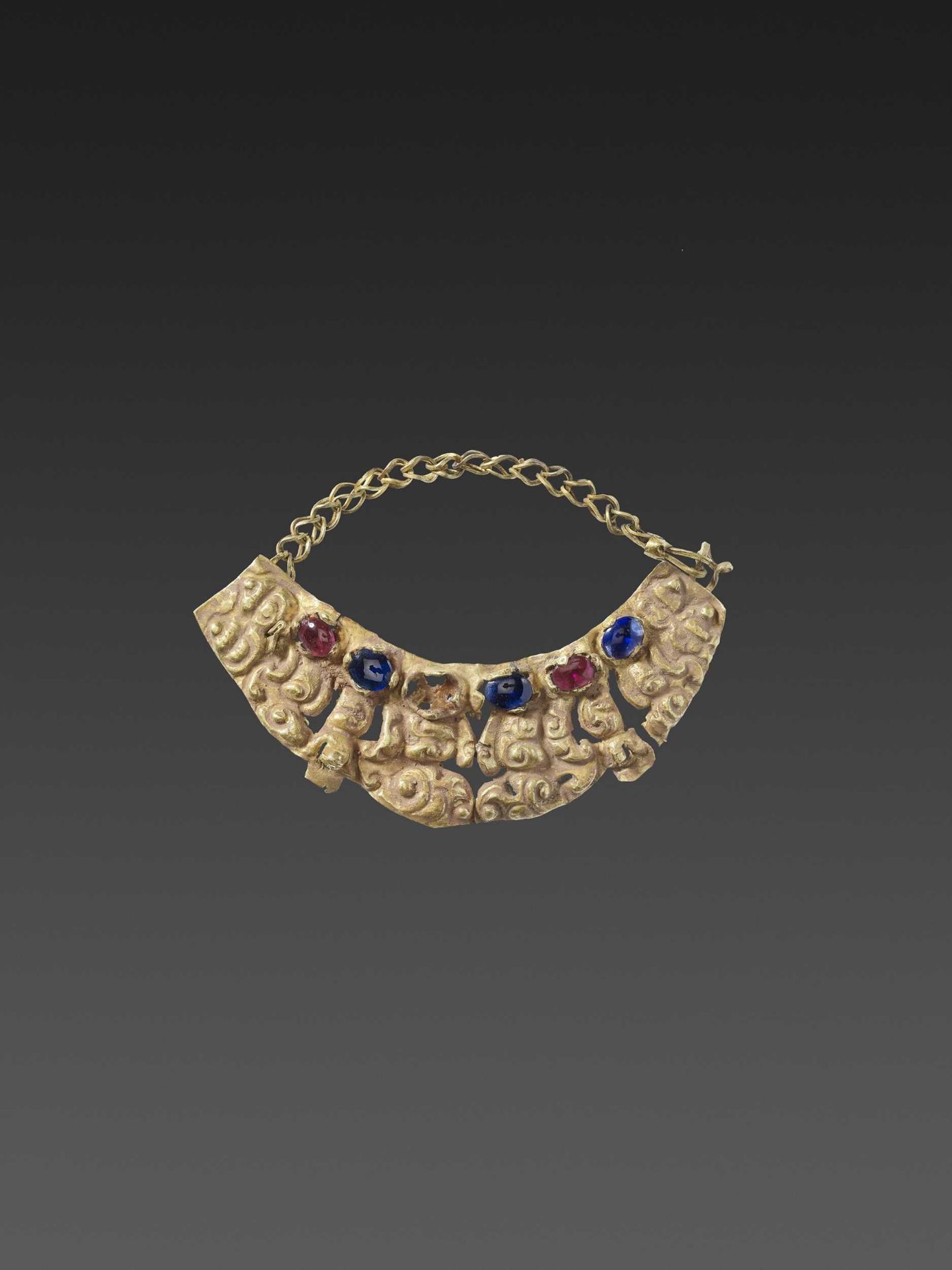 A KHMER RUBY AND SAPPHIRE-SET GOLD REPOUSSÉ PECTORAL