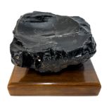 Stone Obsidian, with wooden base. H 13x20 cm.