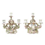 Pair of porcelain candlesticks with three lights depicting figurines and floral decorations, XX