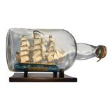 Sailing ship in a glass bottle, with a wooden base. XX century. Cm 20x37.