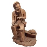 Terracotta figurine depicting monochrome old man sitting with water bottle, Caltagitrone. H 30 cm