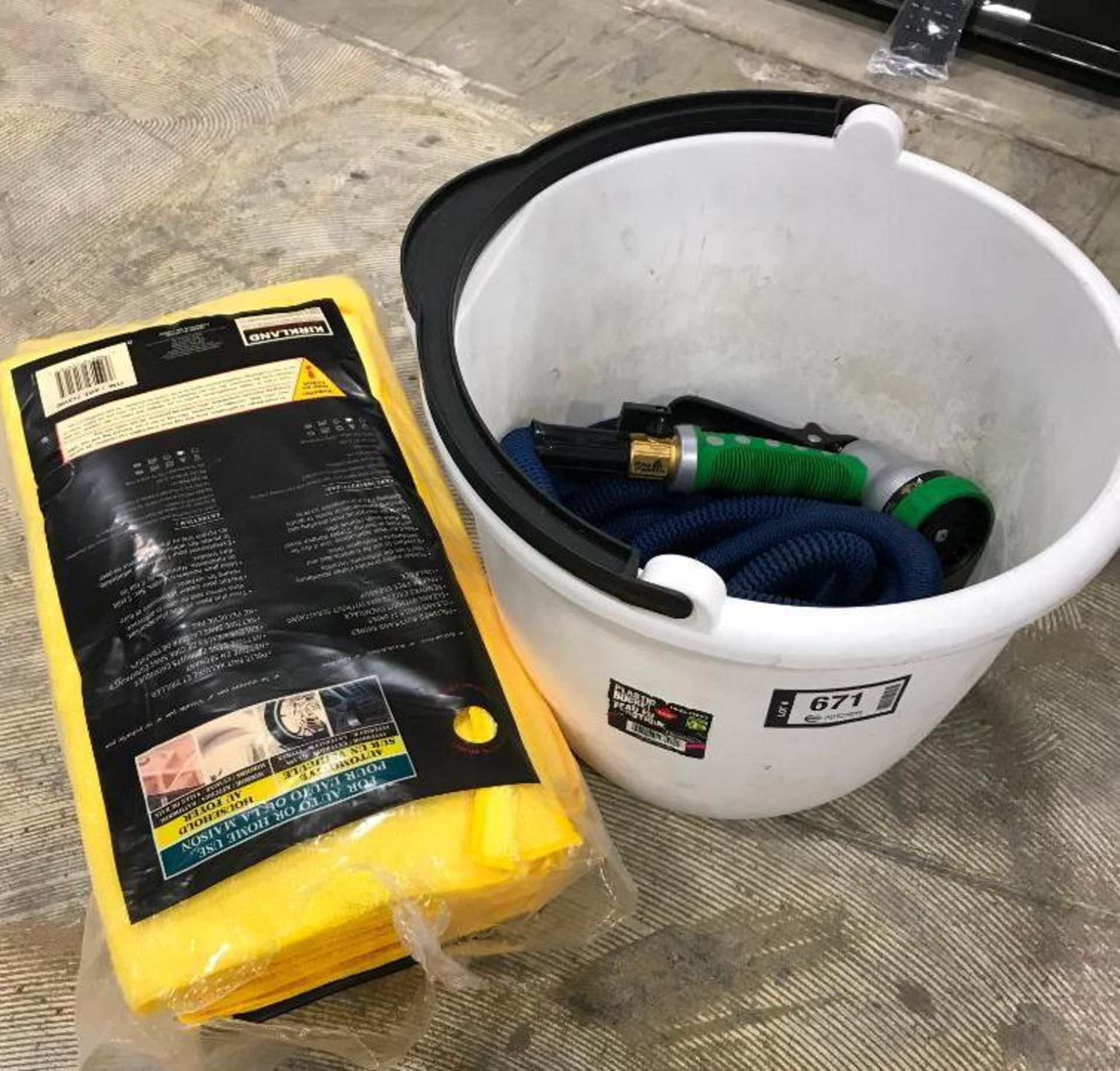 WHITE PLASTIC BUCKET WITH HOSE AND SPRAY NOZZLE & BAG OF YELLOW CLOTHS & RATCHET STRAP