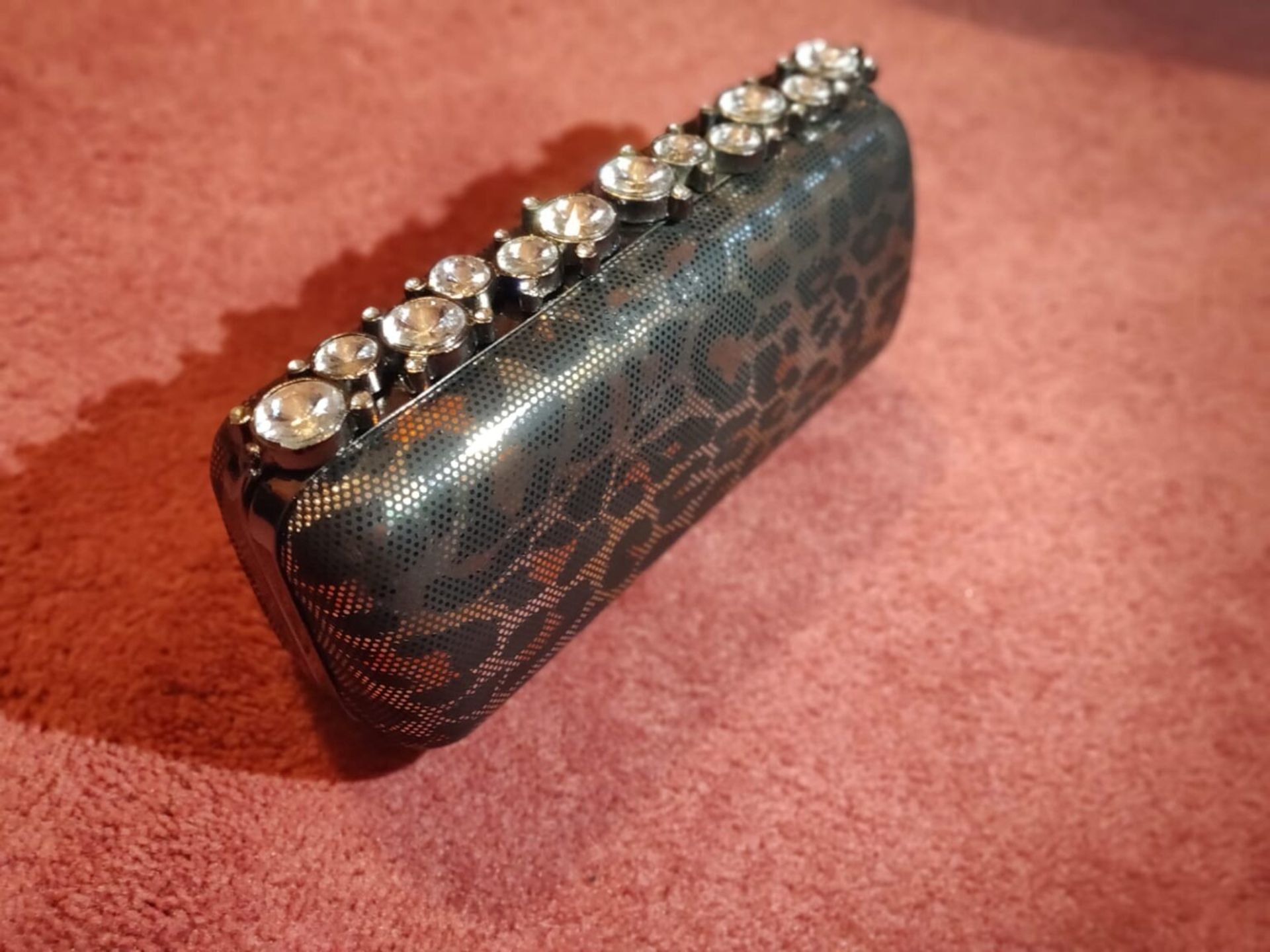 Tinted leopard print black and silver finish clutch bag.