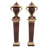 A pair of porphyry vases on pedestals