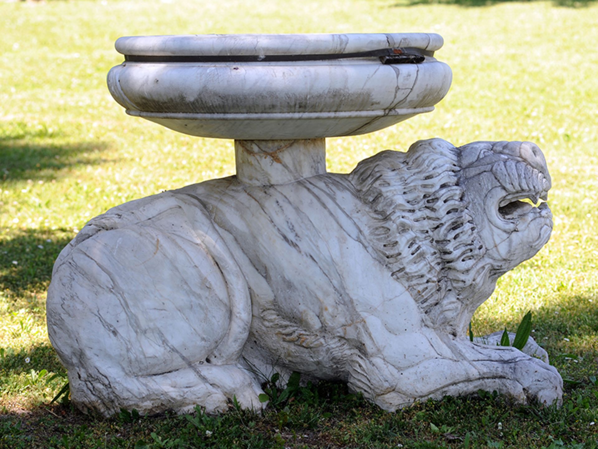 Löwenfigur mit Becken 130 x 95 cm. Italien. In Carrara-Marmor vollplastisch gestalteter Löwe in