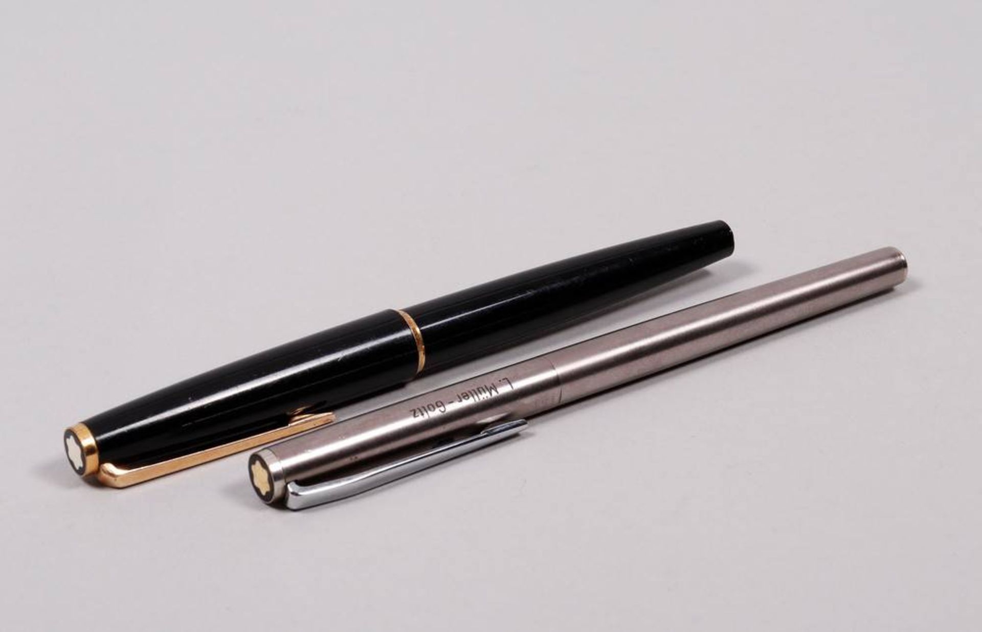2 Fountain pens Montblanc, 1x steel, 1x black plastic, L: 13,5-14cm, signs of use, 1 with engraved