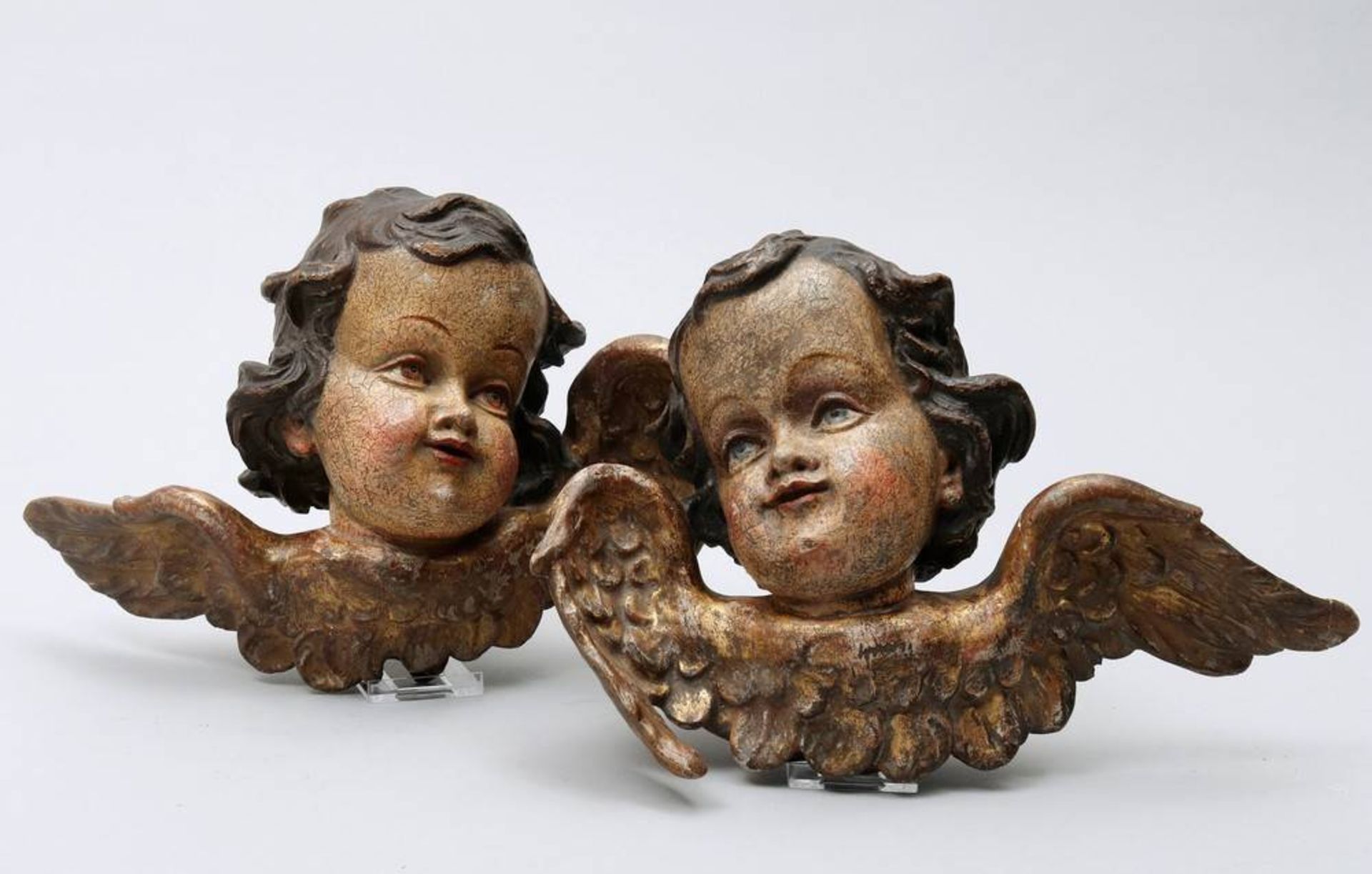 2 figural carvingssouth german, 20th C., pair of winged cherubs heads, carved wood, painted in