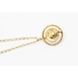 A world planet pendant on a 9ct gold chain, the world within a rotating border, diameter approx.