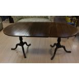 A Georgian style mahogany dining table, D-shaped ends attached with an extra leaf, raised on