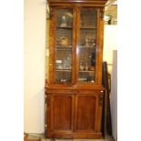 A Victorian framed mahogany glazed bookcase on a cabinet base.