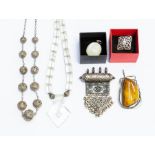 A collection of jewellery to include a butterscotch amber pendant encased within a metal mount,