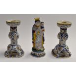 A pair of French Quimper candlesticks, together with a religious Quimper figure. (3)