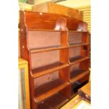 A 20th Century mahogany waterfall bookcase, two joined five tier shelving with a divider in the