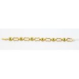 An emerald and unmarked yellow metal (possibly 18ct) gold fancy link bracelet, set with six oval