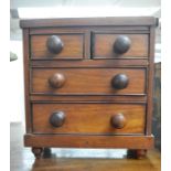 A Victorian mahogany apprentice chest of drawers fitted with two short over two long drawers, turned