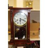 A wall clock together with a reproduction carriage clock.