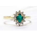 An emerald, diamond and 18ct gold cluster ring, comprising an oval cut emerald to the centre with