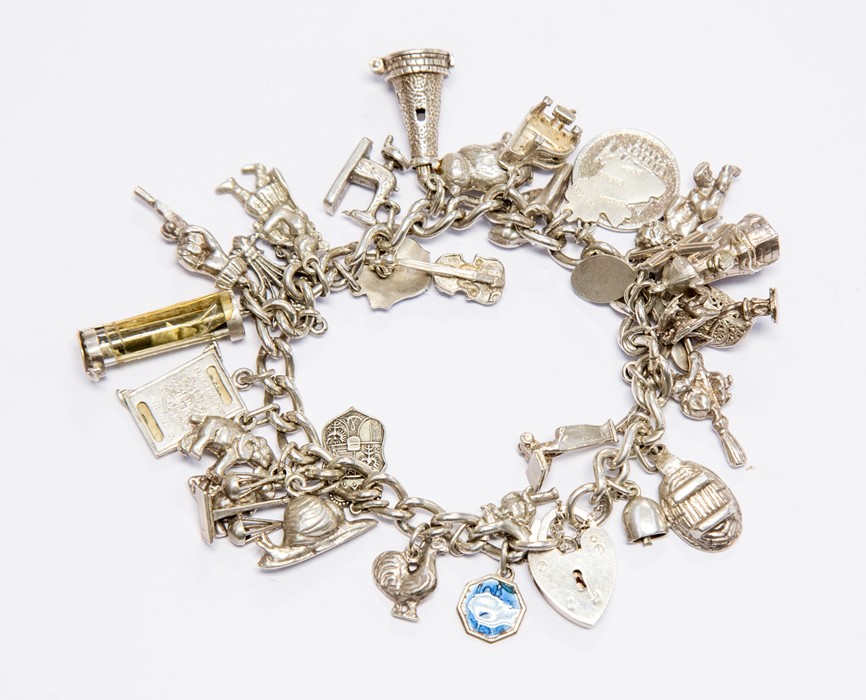 A Sterling silver charm bracelet, fitted with over 30 cast charms, 91.68 grams