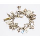 A Sterling silver charm bracelet, fitted with over 30 cast charms, 91.68 grams