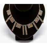 A silver modernist necklace, comprising a fringe front with alternate rectangular and elongated
