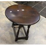 A 20th Century oak low drop leaf table, oval twist action top, on turned supports united on square