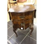 A Queen Anne style walnut bedside table, bow front fitted with two dropleaves either side, above two