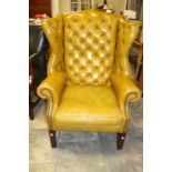 A 20th Century leather chesterfield wingback armchair.