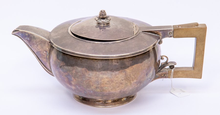 An Art Deco silver melon shaped teapot, planished finish with raised body, rose bud finial and