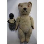An English early 20th Century teddy bear, articulated and body beige fur, orange eyes, leather paws,