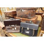 A collection of ten various suitcases and briefcases, leather and leatherette, with faux crocodile