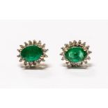 A pair of emerald and diamond 9ct gold cluster earrings, comprising oval cut emeralds with a diamond