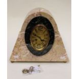 A stylish beige and black marble Art Deco mantel clock, the brass coloured oval dial is surrounded