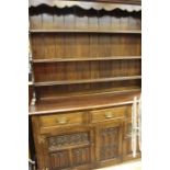 A 20th Century oak welsh dresser, moulded cornice, shelves fitted with plate supports, on a