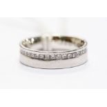 A diamond and platinum full set eternity ring, comprising an offset row of princess cut diamonds