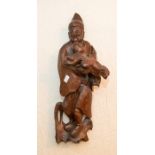 A 19th century Chinese wood carving of an elder carrying child, rustic chisel marks verso,