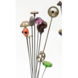 Hat pins- A collection of ten hat pins to include a carved seed in the form of a monkey's face,