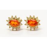 A pair of 9ct gold cluster earrings set with orange oval stones possibly fire opal, diamond set
