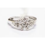 A diamond round-cluster hallmarked 18ct white gold ring, with diamond set shoulders, a total of