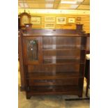 A 20th Century oak open bookcase, gallery top, above four tier shelves fitted with one panel