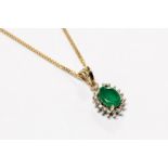 An emerald and diamond 9ct gold cluster pendant, comprising a central set emerald approx. 5mm x 7mm,