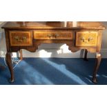 A George II oak lowboy, the long central drawer flanked by two square drawers, later brass
